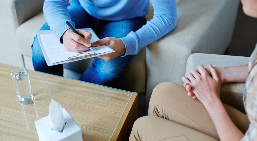 Psychological therapy Male psychologist making notes during psychological therapy